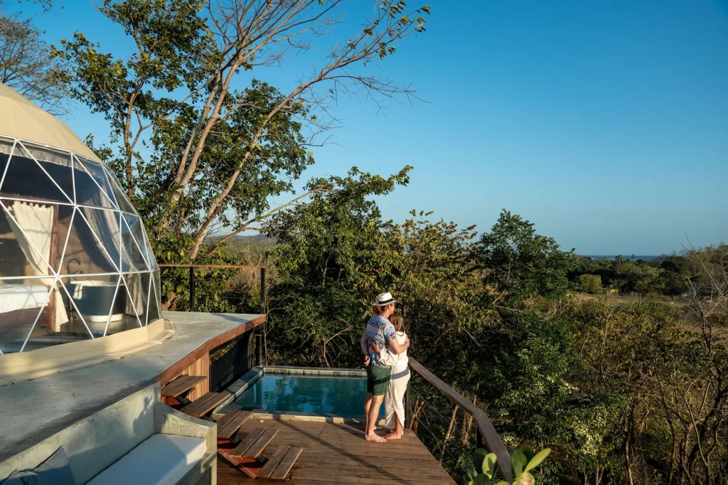 A young couple enjoying the outdoor space outside one of the rooms at Alaya Panama, surrounded by nature and tranquility.