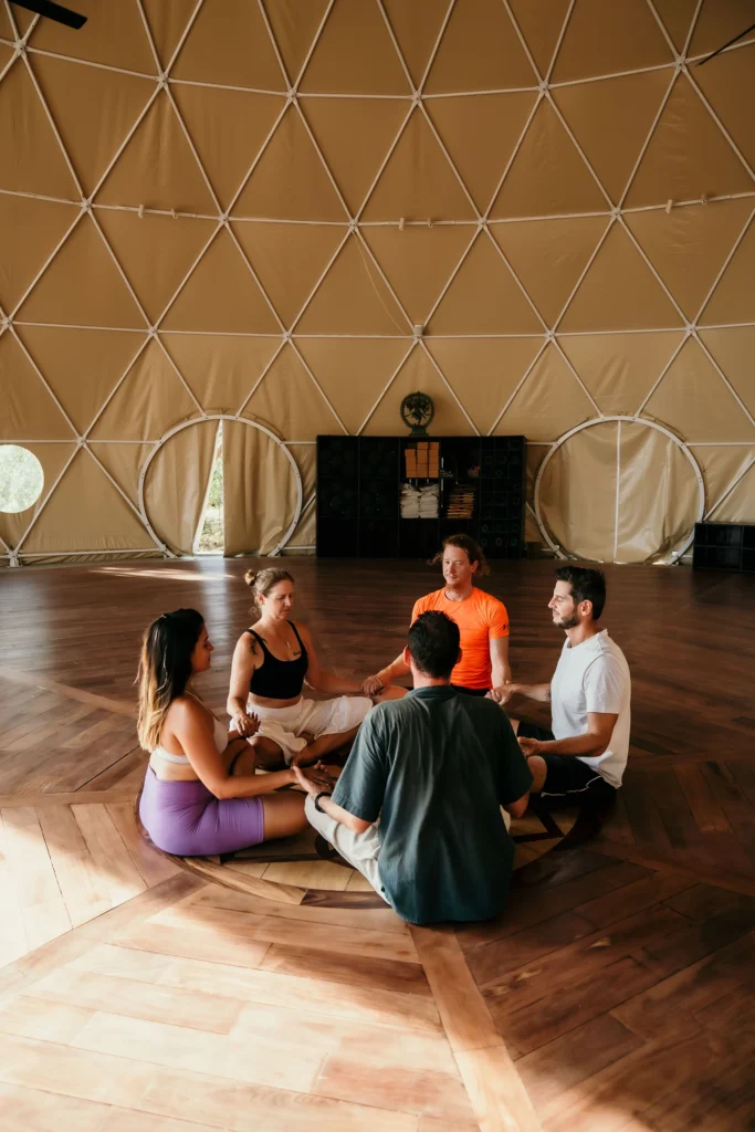 A group of guys practicing meditation in the main hall at Alaya Panama, immersed in tranquility and focused on mindfulness.