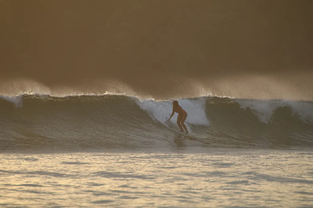 A girl riding the waves while surfing at Alaya Panama