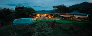 Drone shot of the Alaya infinity pool at golden hour with jungle and Pacific ocean in the background